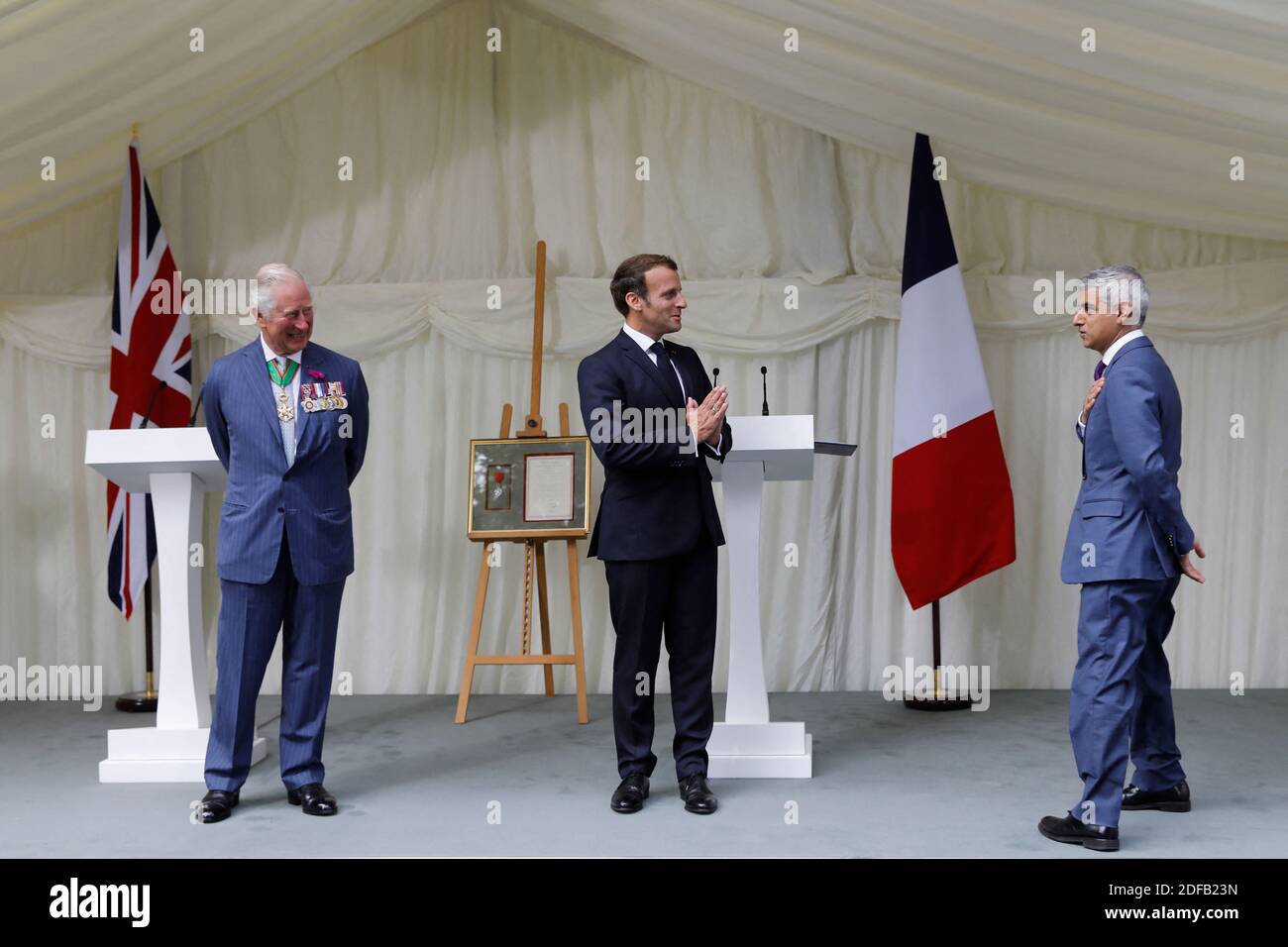 Britain's Prince Charles, Prince of Wales (L) French President Emmanuel Macron (C) and London Mayor Sadiq Khan (R) exchange greetings after a ceremony to present the Legion d'Honneur – France's highest distinction – to London for services during WW2 at Carlton Gardens in central London on June 18, 2020 during a visit to mark the anniversary of former French president Charles de Gaulle's appeal to French people to resist the Nazi occupation. - Macron visited London on June 18 to commemorate the 80th anniversary of former French president Charles de Gaulle's appeal to French people to resist the Stock Photo