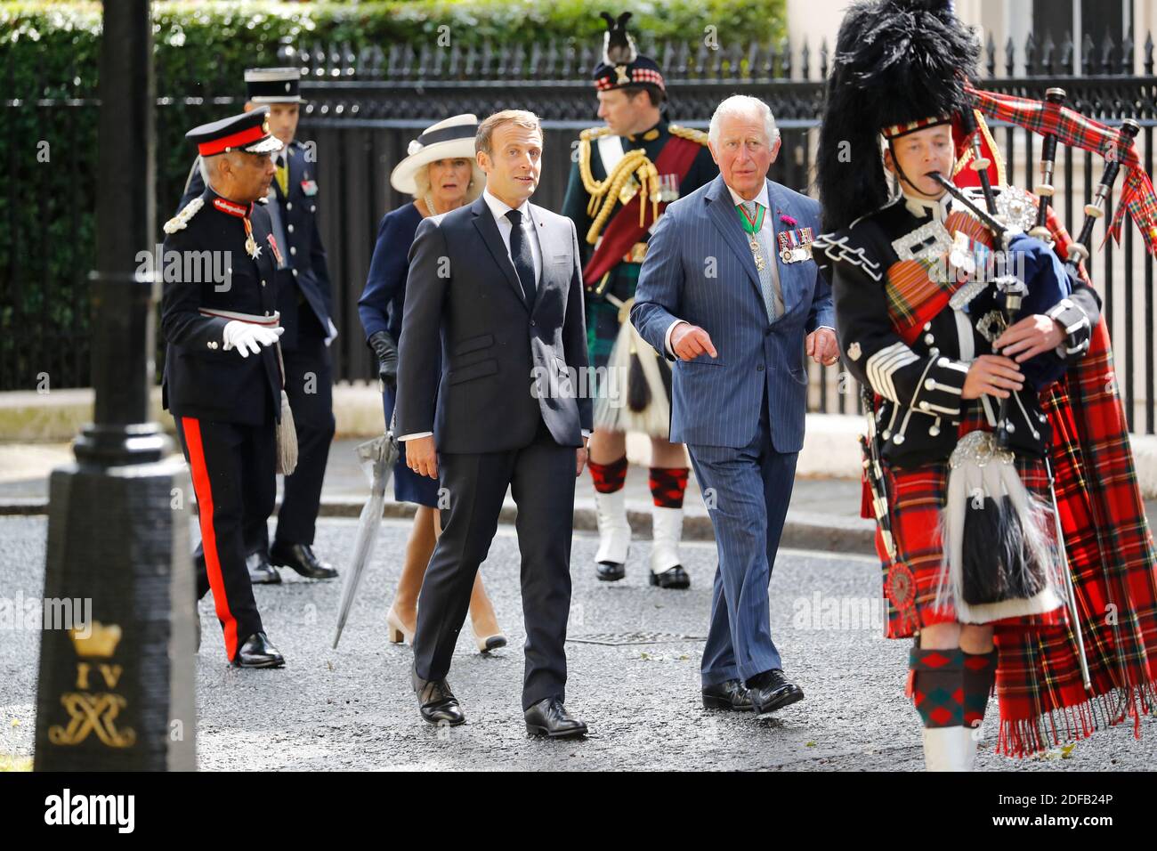 Britain's Camilla, Duchess of Cornwall (3rd L), Britain's Prince Charles, Prince of Wales (2nd R) and French President Emmanuel Macron (4th L) follow a piper as they arrive to lay wreaths at the statue of former French president Charles de Gaulle at Carlton Gardens in central London on June 18, 2020 during a visit to mark the anniversary of former de Gaulle's appeal to French people to resist the Nazi occupation. - Macron visited London on June 18 to commemorate the 80th anniversary of former French president Charles de Gaulle's appeal to French people to resist the Nazi occupation during Worl Stock Photo