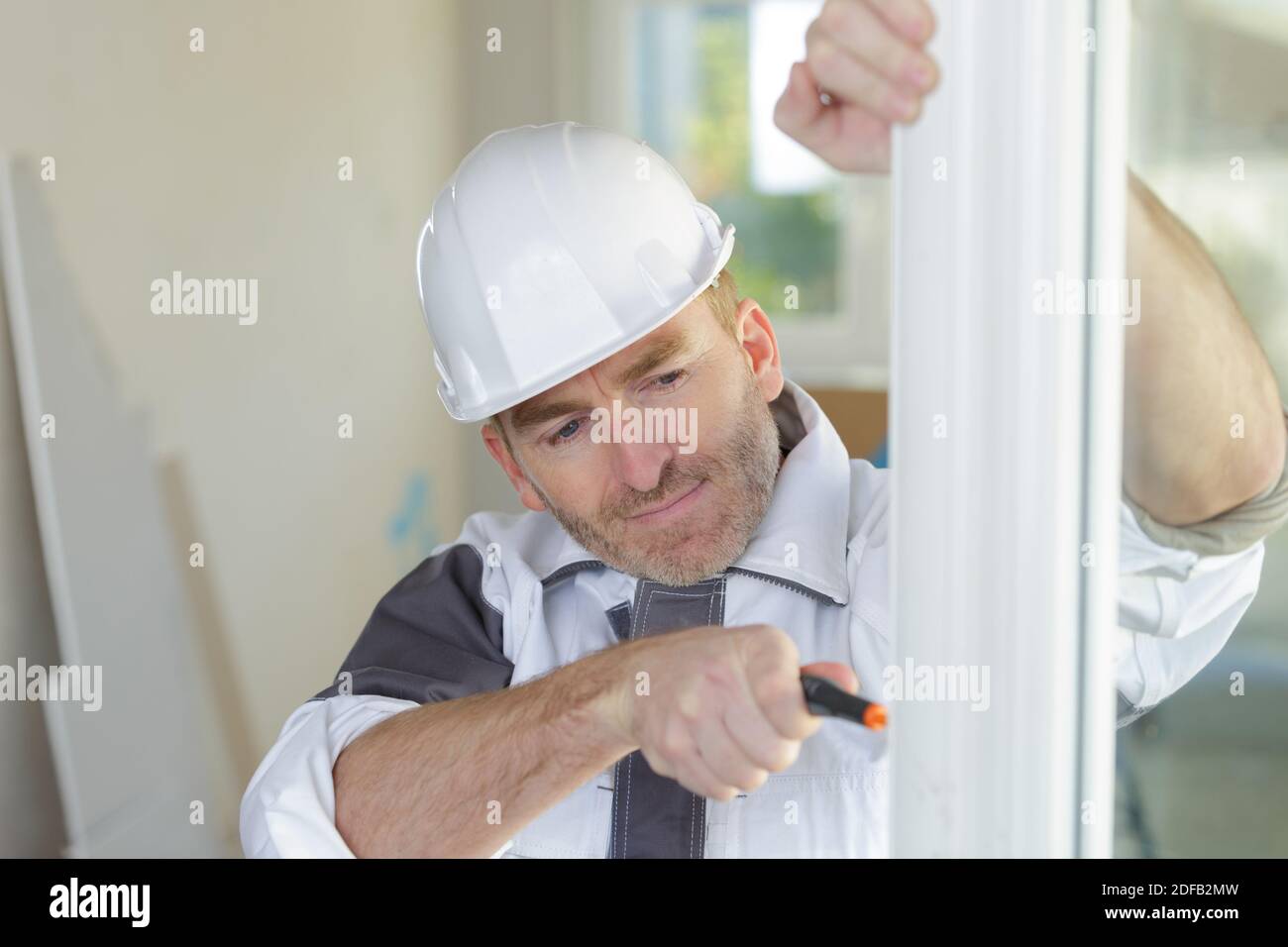 Worker fitting upvc window frame Stock Photo Alamy