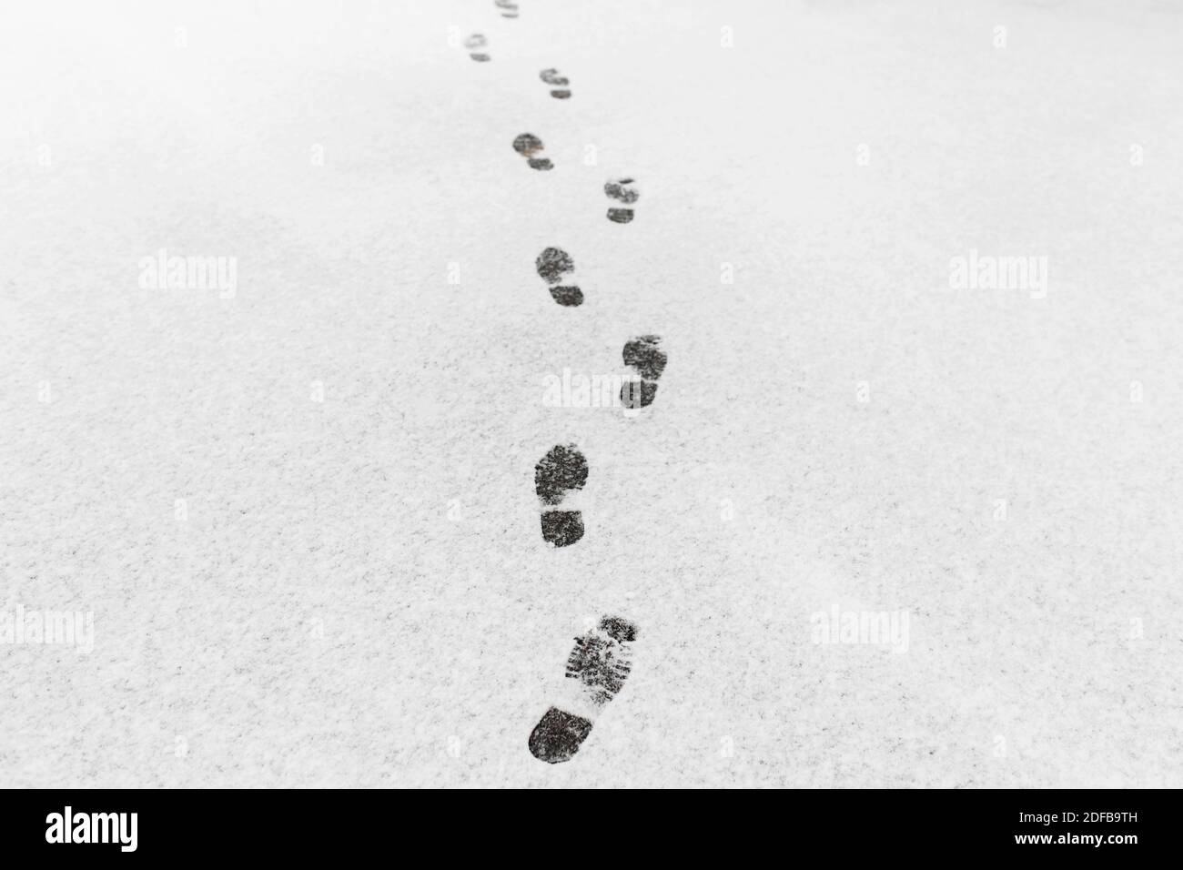 A man walked, he left footprints in the snow. Isolated text Stock Photo