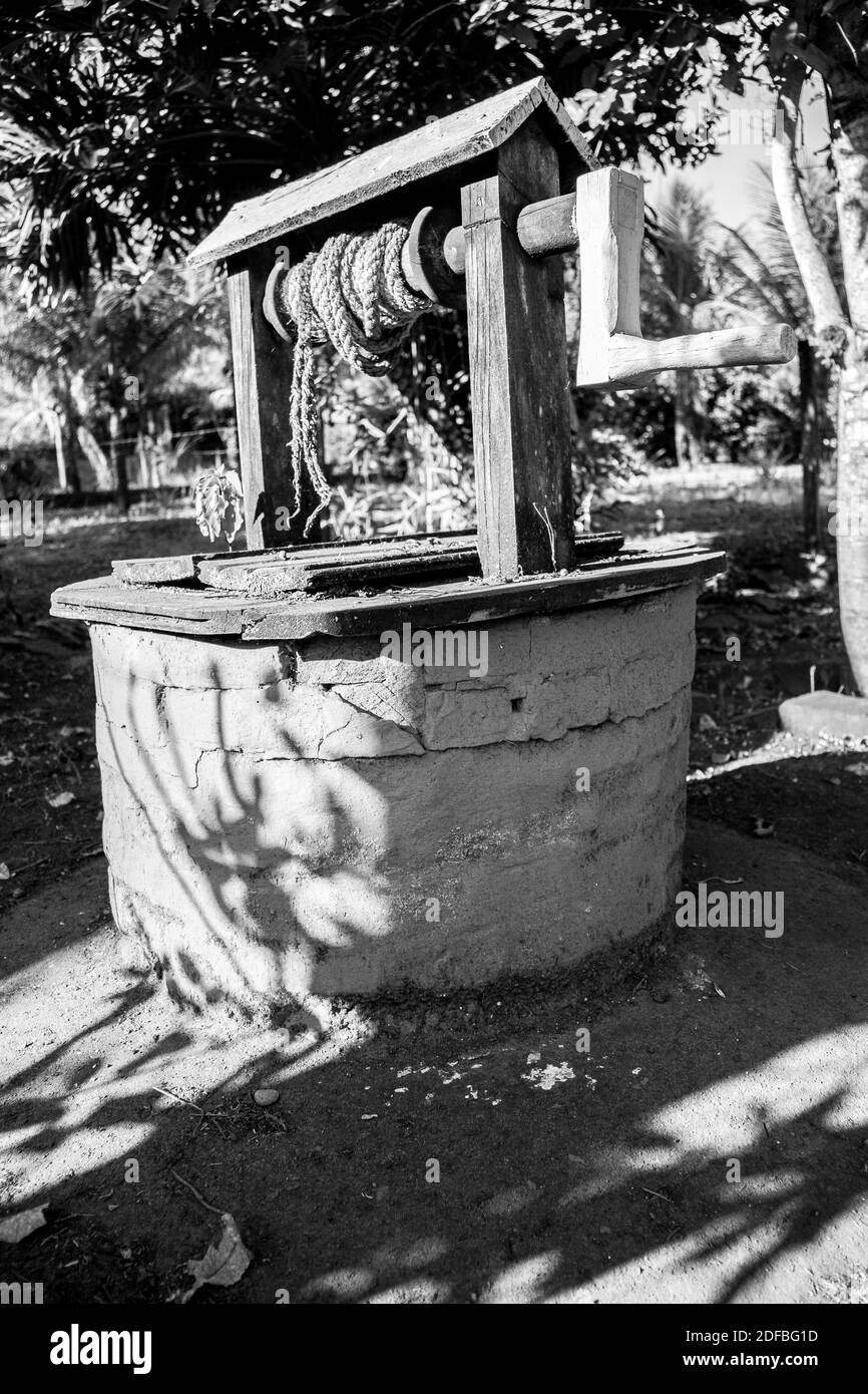Colorful retro well of water with rope placed at a farm in the countryside [Black and white] Stock Photo