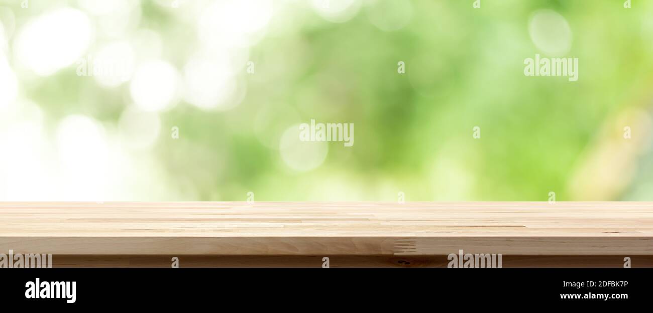 Wood table top on natural bokeh green background, panoramic banner - can be used for display or montage your products Stock Photo