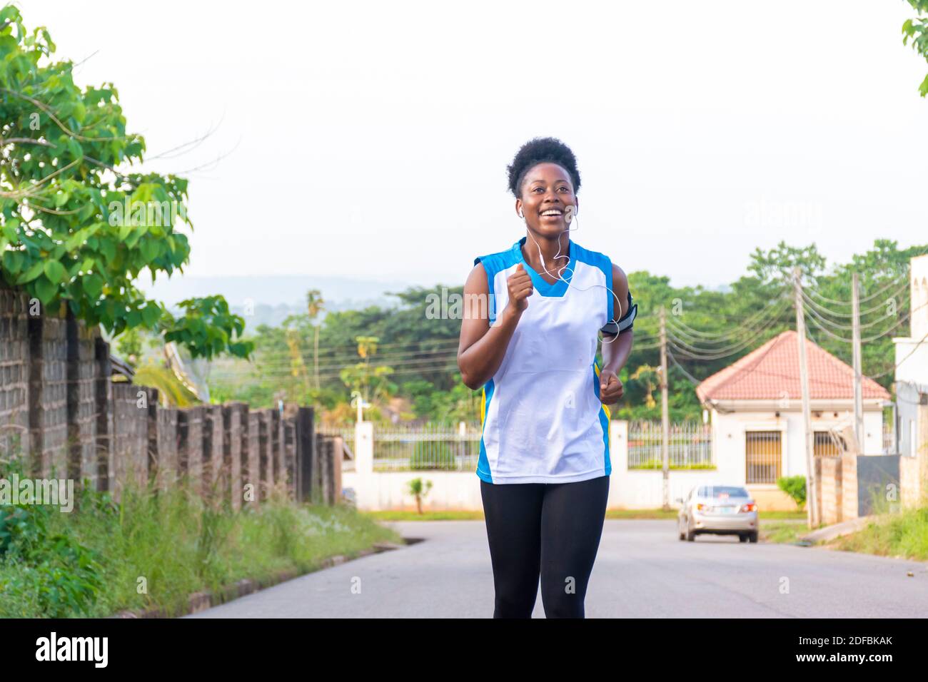 african lady going for a run and listening to music while she runs Stock Photo