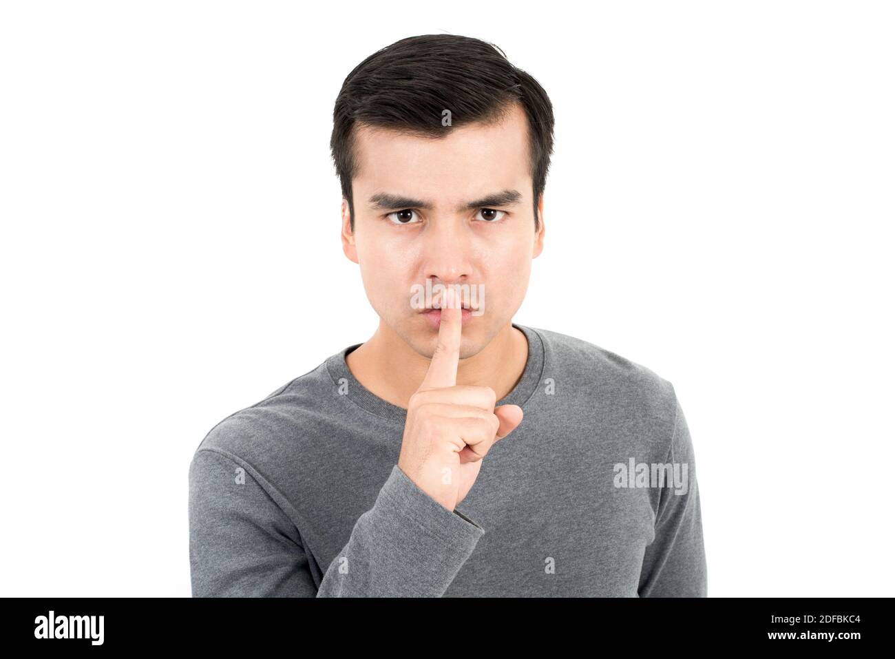 Young man making hush (shh) gesture - quiet or secret sign Stock Photo