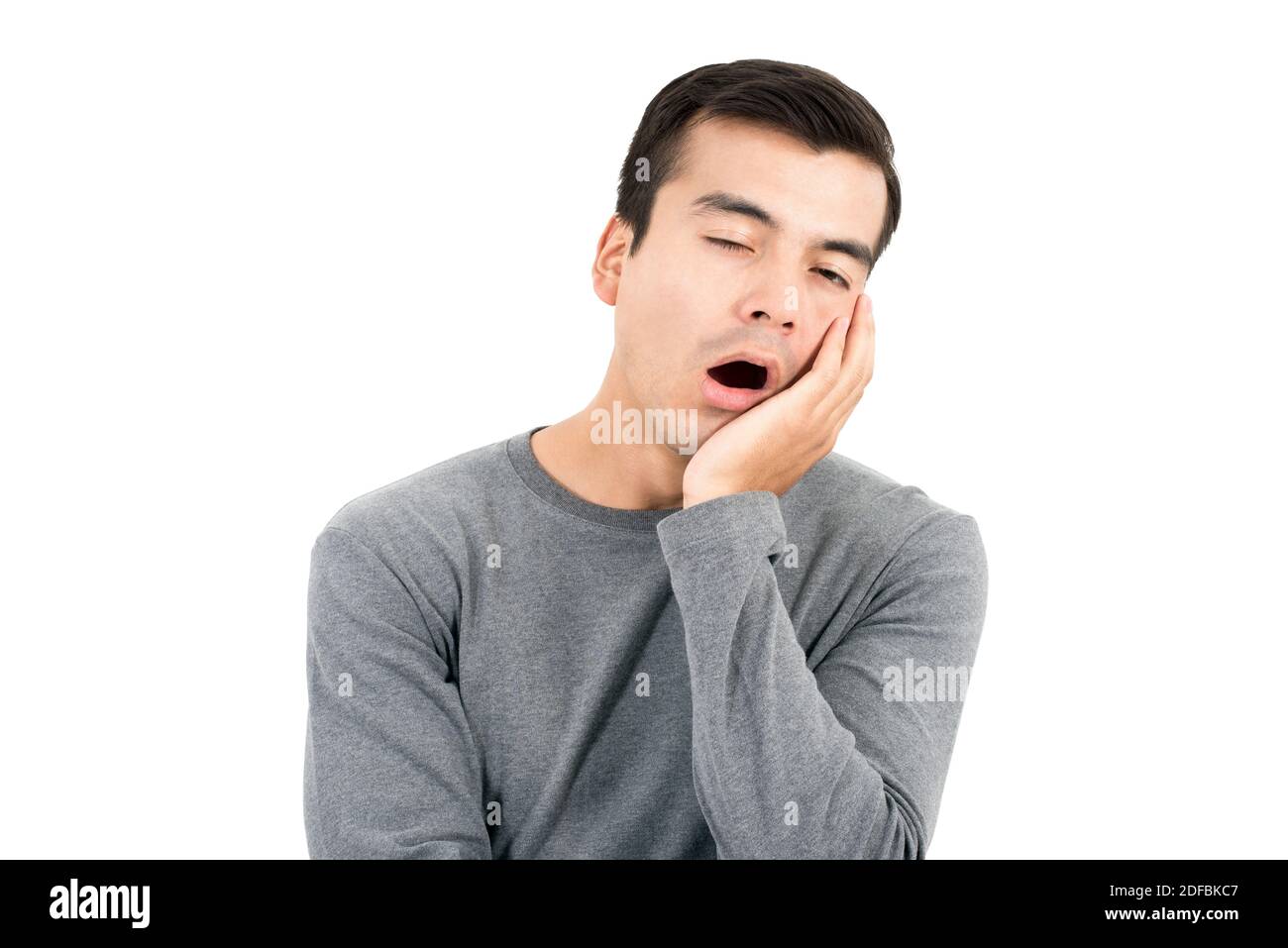 Bored and sleepy man yawning with hand on cheek - isolated on white background Stock Photo