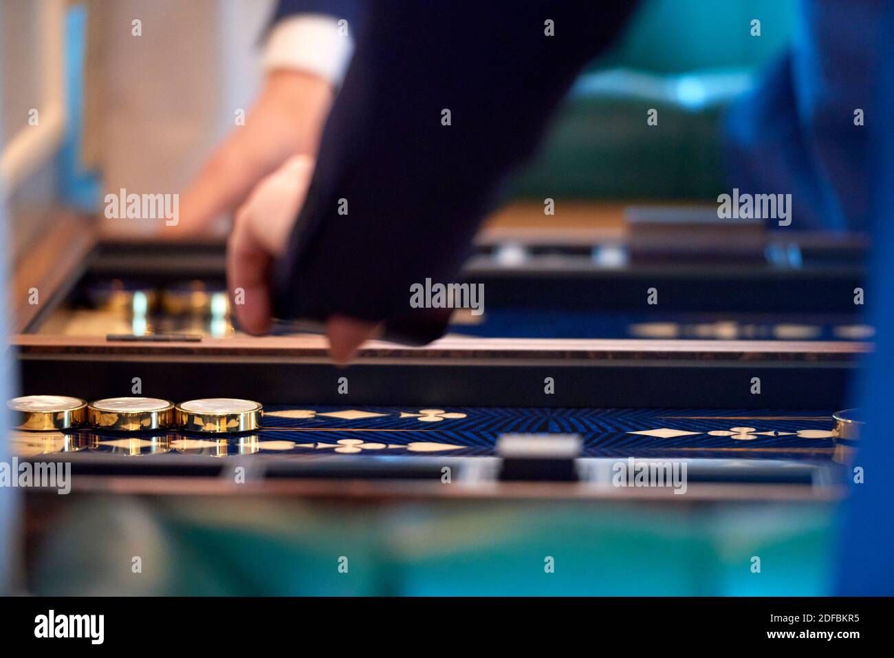 A game of Backgammon been played with close ups of hands and dice Stock Photo