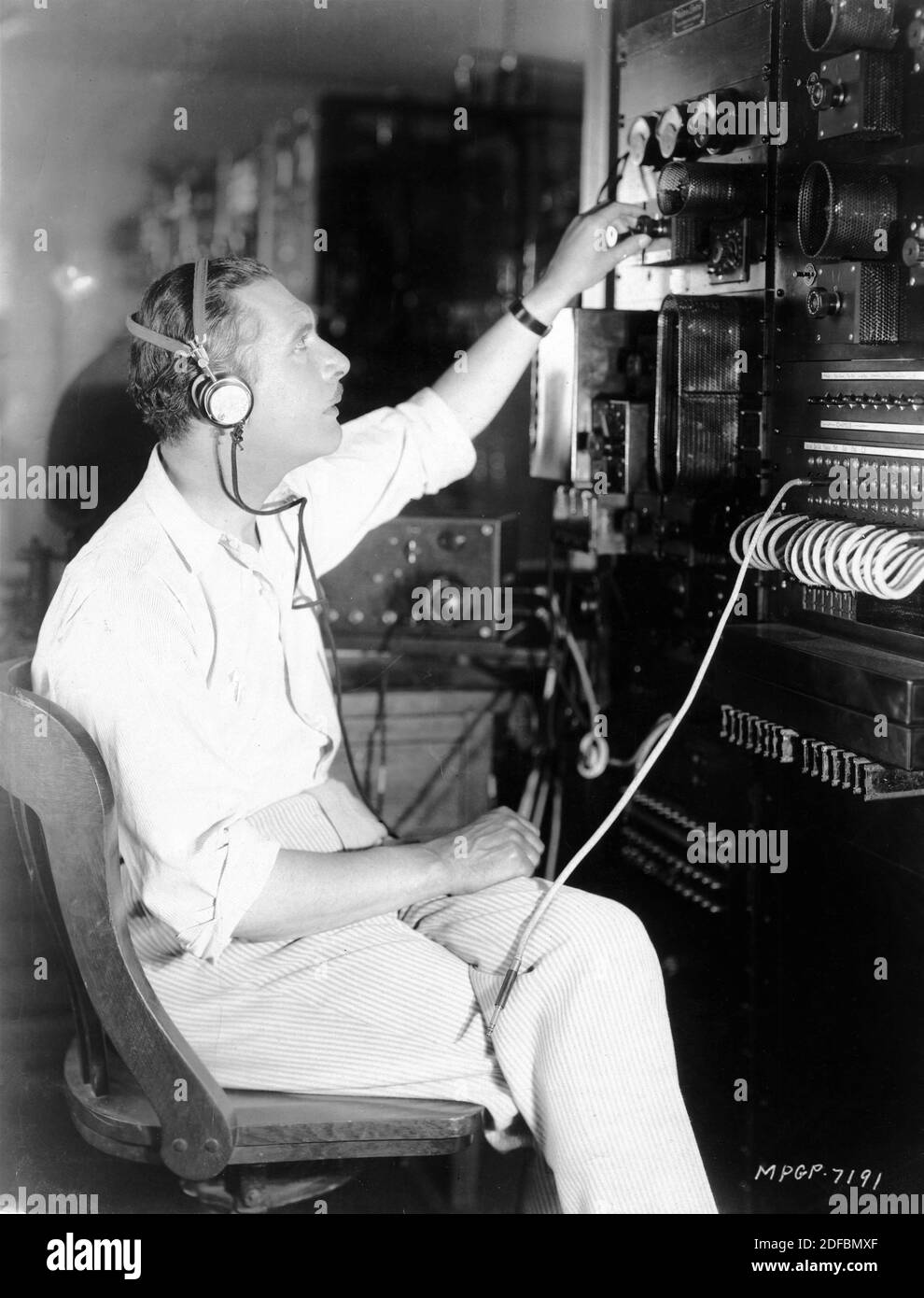 LEW CODY in the Control Room of KFI Radio Station during Early Experiment in Sound for NORMA SHEARER and LEW CODY in A SLAVE OF FASHION 1925 director HOBART HENLEY Metro Goldwyn Mayer Stock Photo