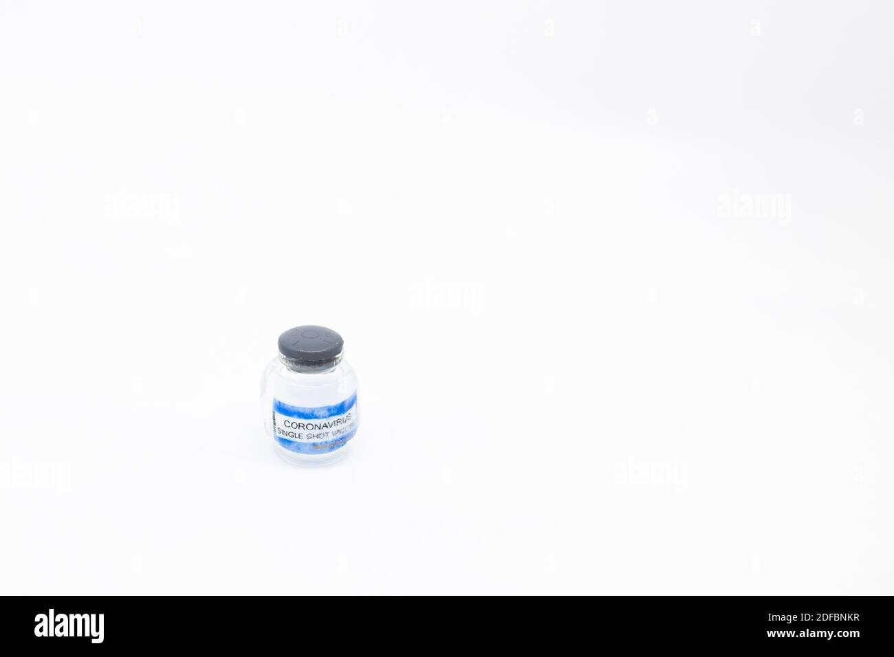 Slowly melting ice cube with COVID dose vaccine frozen inside Concept of very low storage temperatures for corona virus vaccine Glass vial with vaccin Stock Photo
