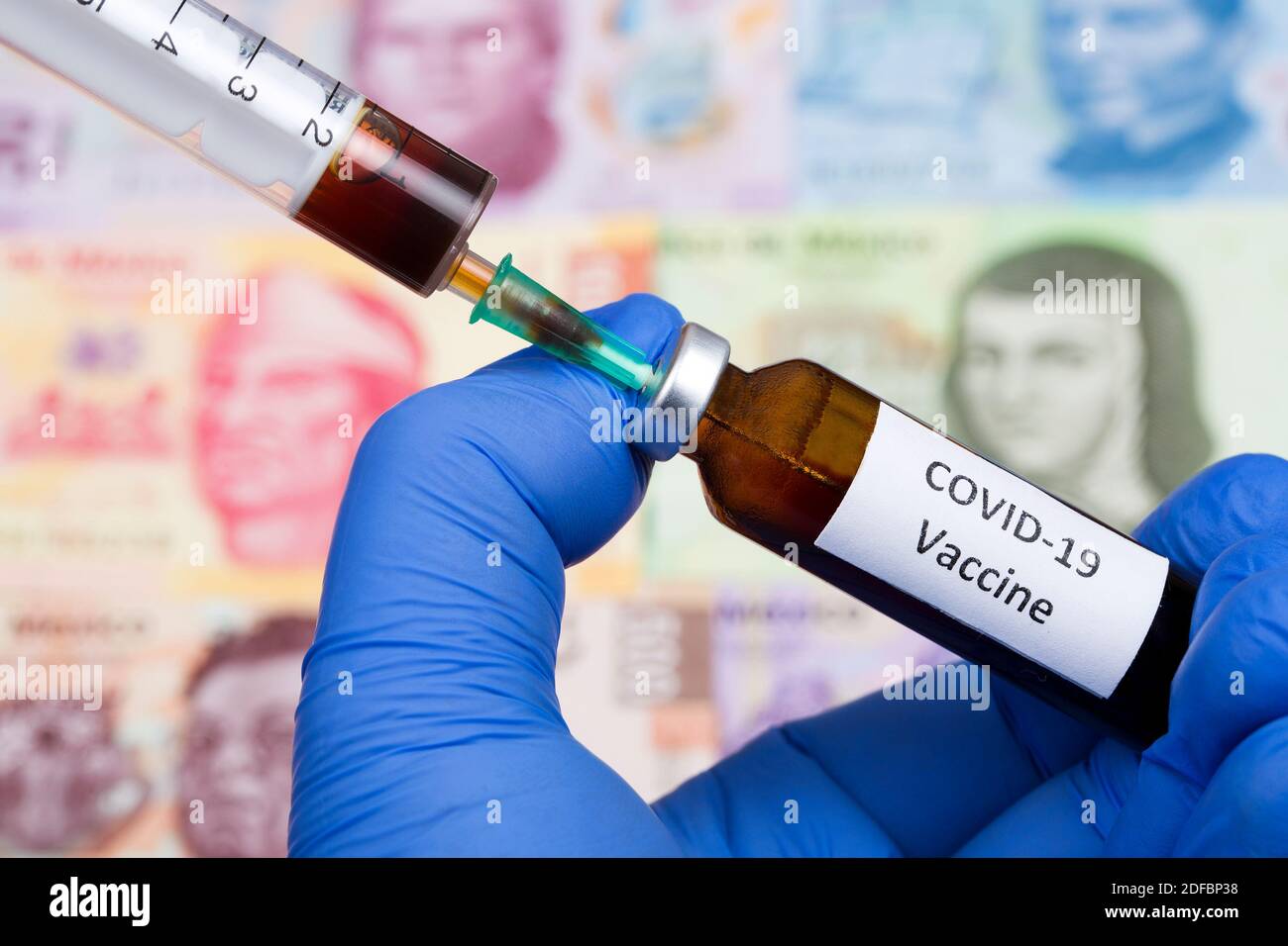 Vaccine against Covid-19 on the background of Mexican money Stock Photo