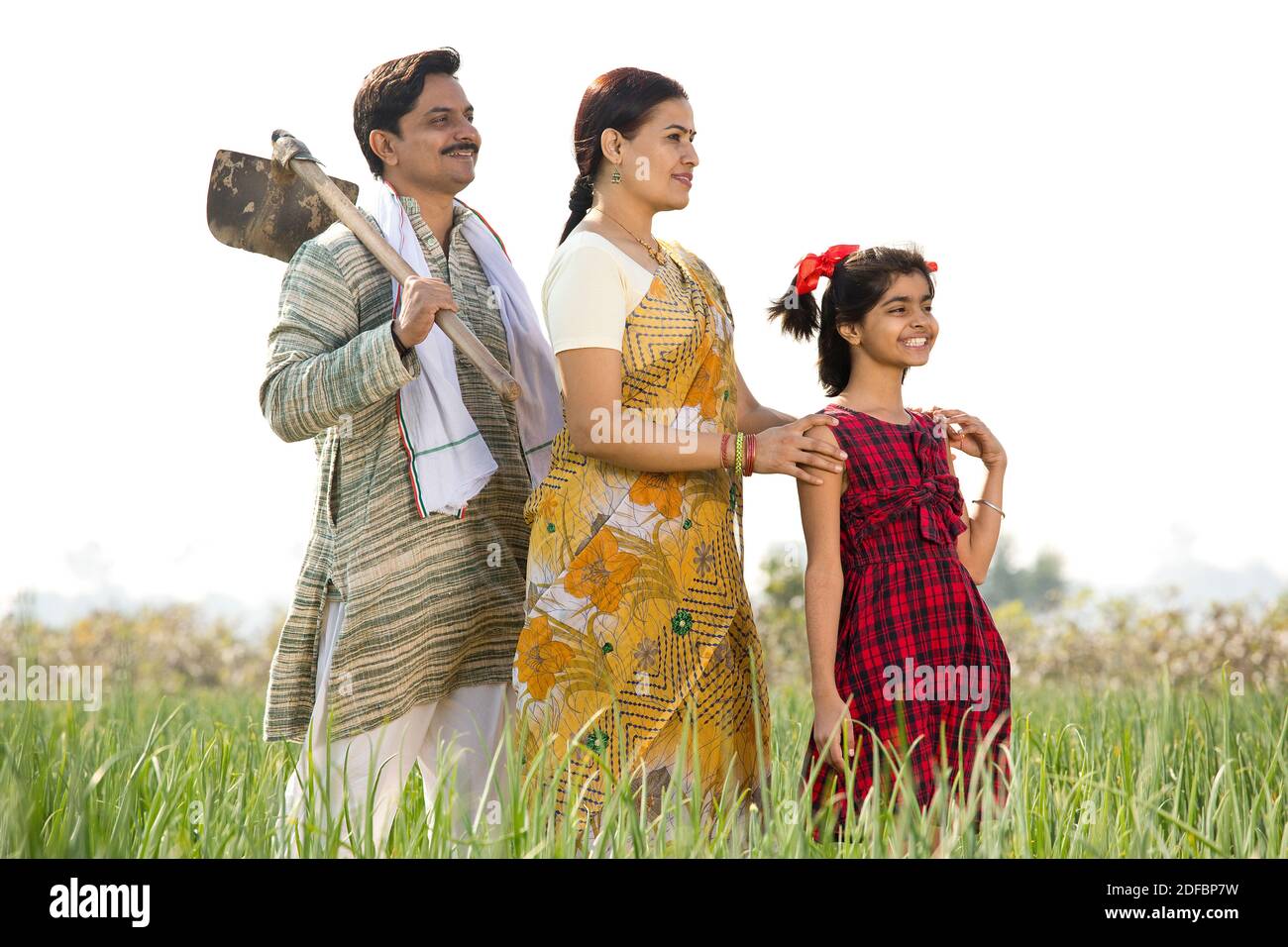 Happy Indian family in agricultural field looking away Stock Photo - Alamy