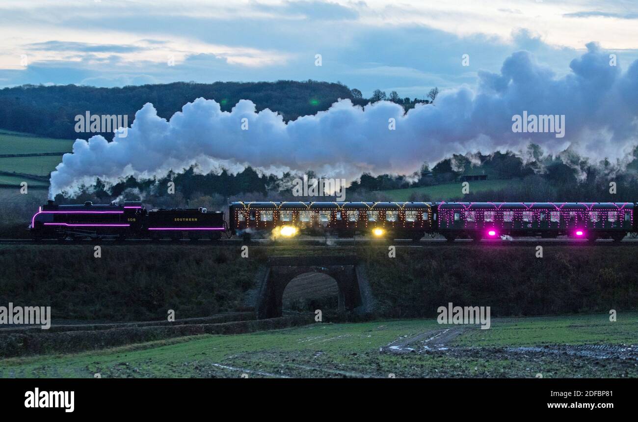 The S15 class steam locomotive 506 pulls the world's first digital LED train, created using thousands of fully controllable colour mixing LED lights, as it makes it's way from Alresford Station to Ropley station in Hampshire during a preview of Steam Illuminations at Watercress Line, which opens to the public on Friday December 4. Stock Photo