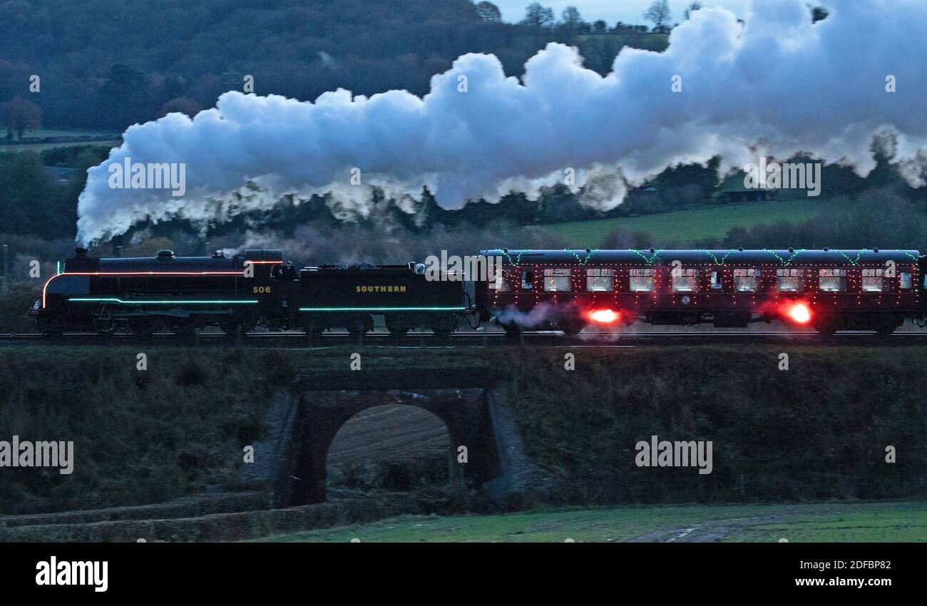 The S15 class steam locomotive 506 pulls the world's first digital LED train, created using thousands of fully controllable colour mixing LED lights, as it makes it's way from Alresford Station to Ropley station in Hampshire during a preview of Steam Illuminations at Watercress Line, which opens to the public on Friday December 4. Stock Photo