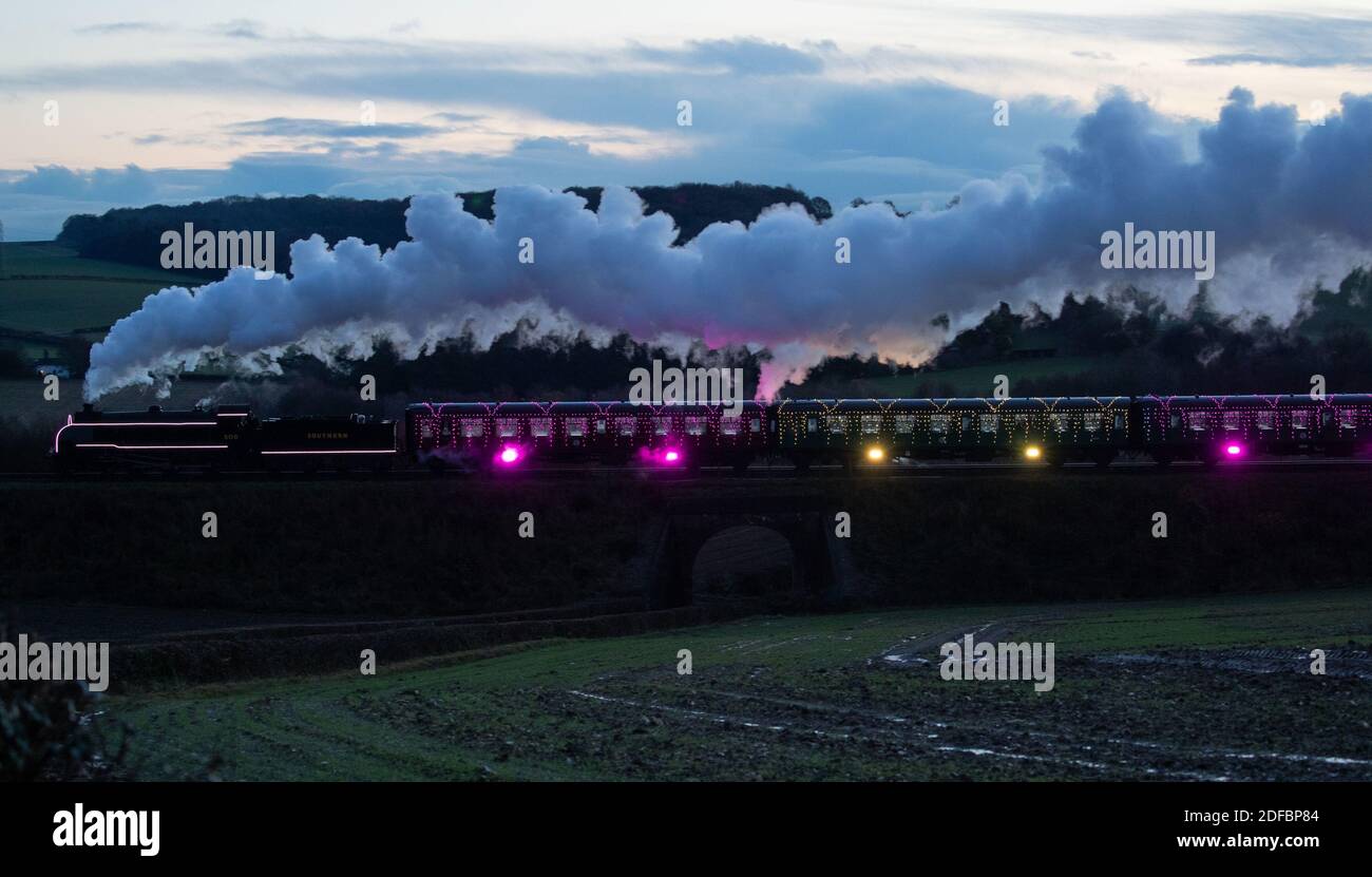 The S15 class steam locomotive 506 pulls the world's first digital LED train, created using thousands of fully controllable colour mixing LED lights, as it makes it's way from Alresford Station to Ropley station in Hampshire during a preview of Steam Illuminations at Watercress Line, which opens to the public on Friday December 4. Stock Photo