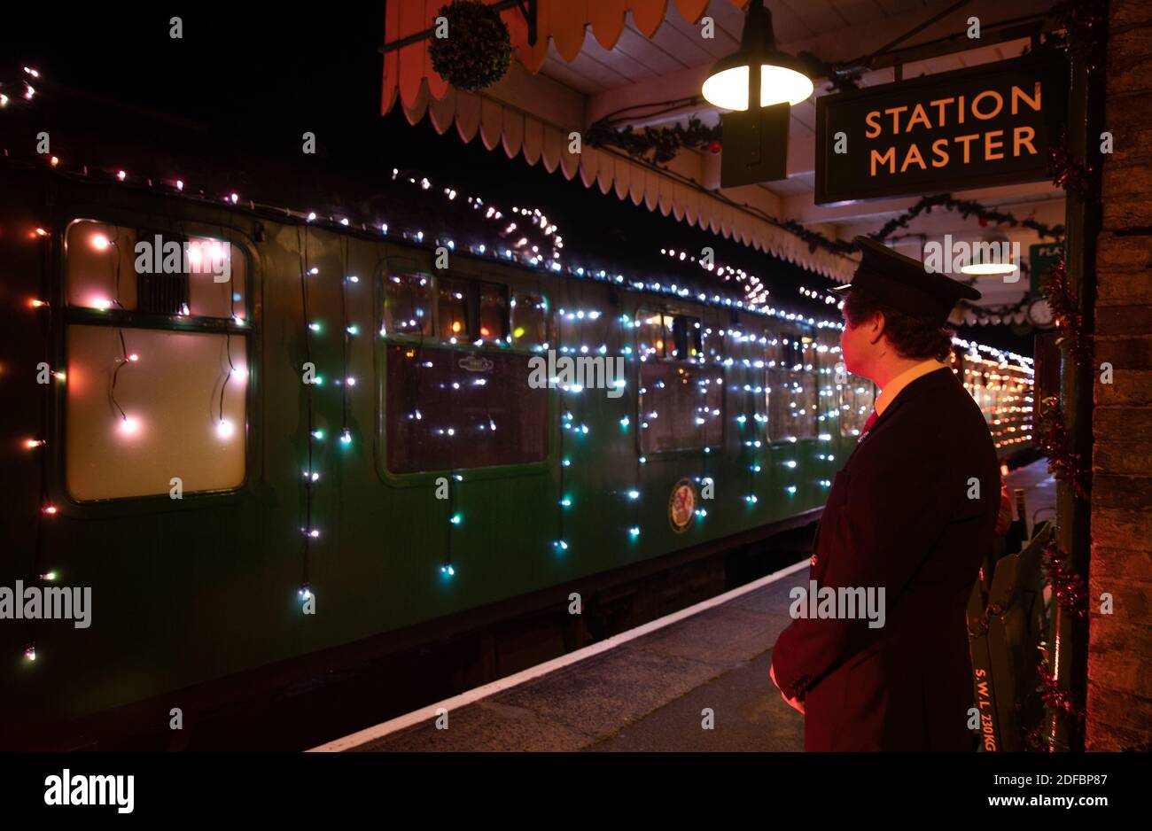 A guard looks at the world's first digital LED train, created using thousands of fully controllable colour mixing LED lights, at Alton station during a preview of Steam Illuminations at Watercress Line, which opens to the public on Friday December 4. Stock Photo