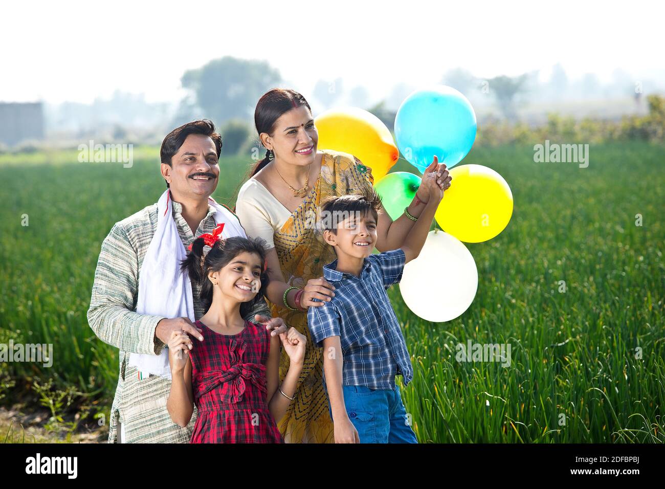 Happy indian family of farmer with balloons in agricultural field Stock ...