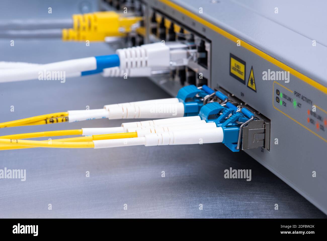 Switch with connected optical fiber patch cords and UTP ethernet cables Stock Photo