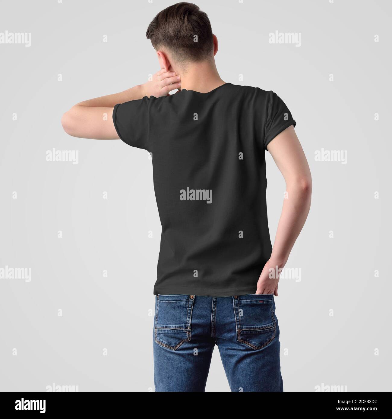 Template of male black t-shirt on a young guy in jeans, rear view, isolated on a white background. Mockup of fashionable clothes for men for the prese Stock Photo