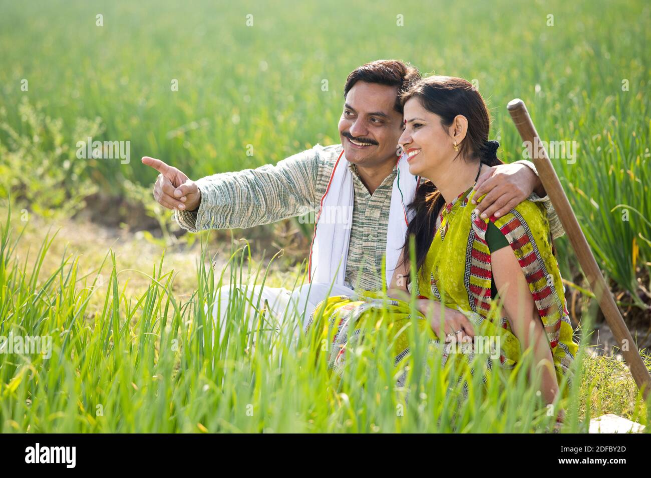 Happy Indian couple farmers examining crop in agricultural field Stock ...