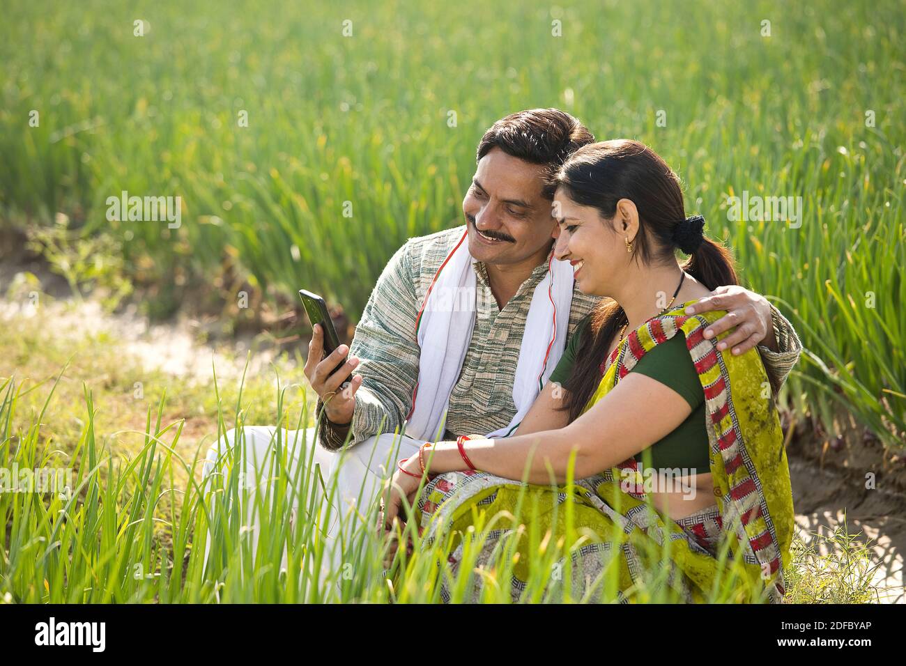 Rural couple using mobile phone in agricultural field Stock Photo