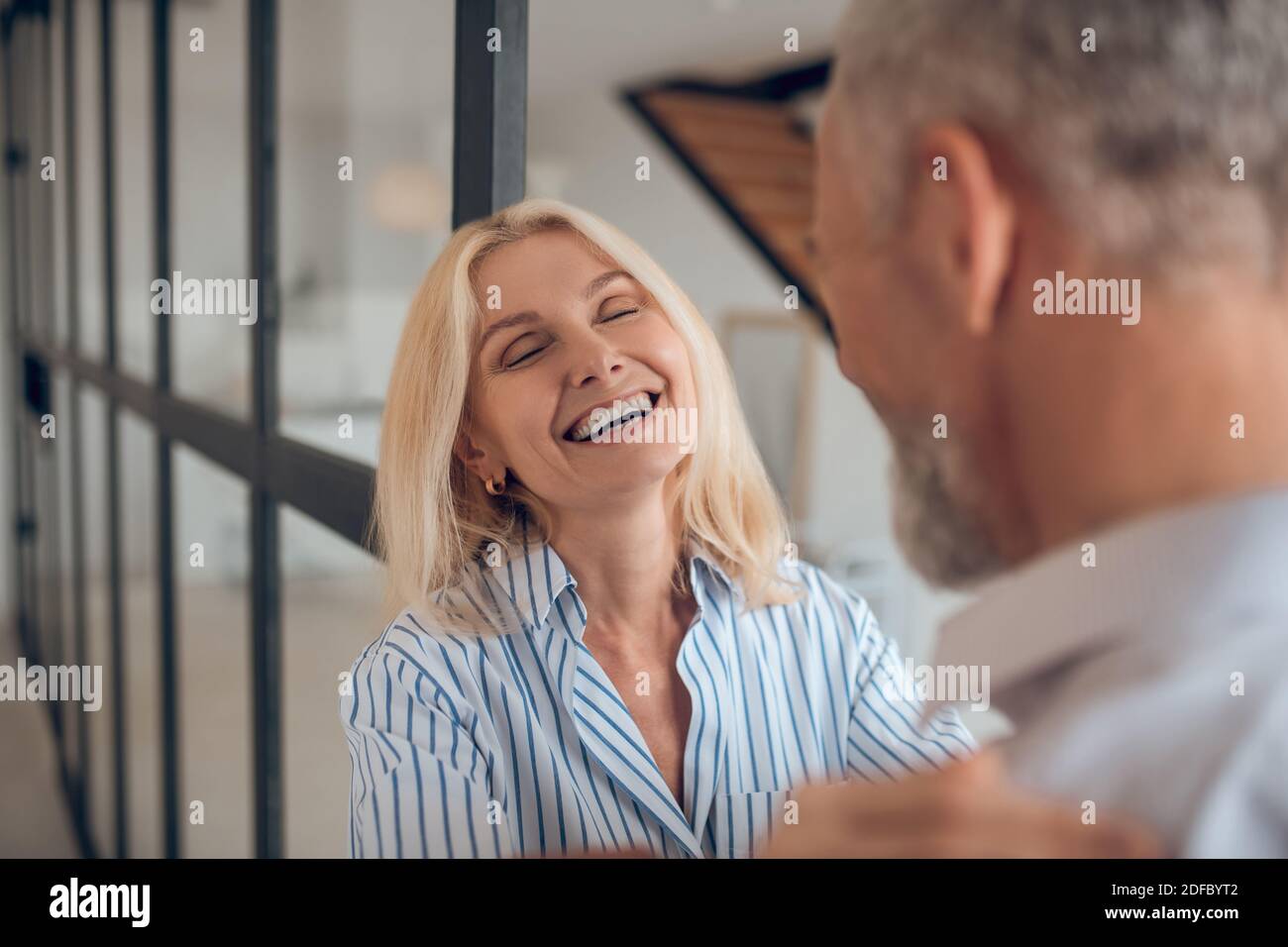 Blonde woman hugging her boyfriend and smiling brightly Stock Photo - Alamy