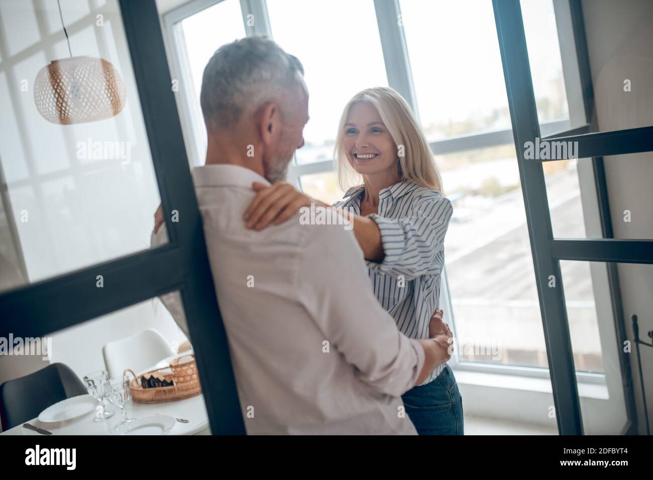 Blonde woman hugging her boyfriend and looking happy Stock Photo - Alamy
