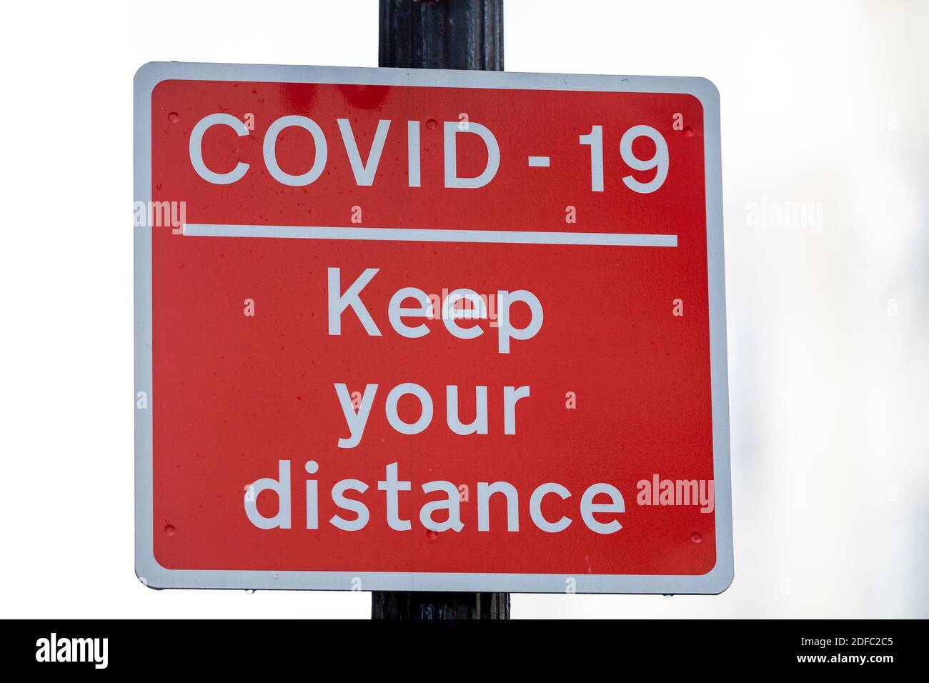 A sign reads Covid-19 Keep your distanceAn increasing number of shops to let around Brighton City Centre which is eerily quiet during the Covid-19 Lockdown 2.0.  Normally with just weeks before Christmas the lanes would be busy with people purchasing gifts for loved ones. Stock Photo