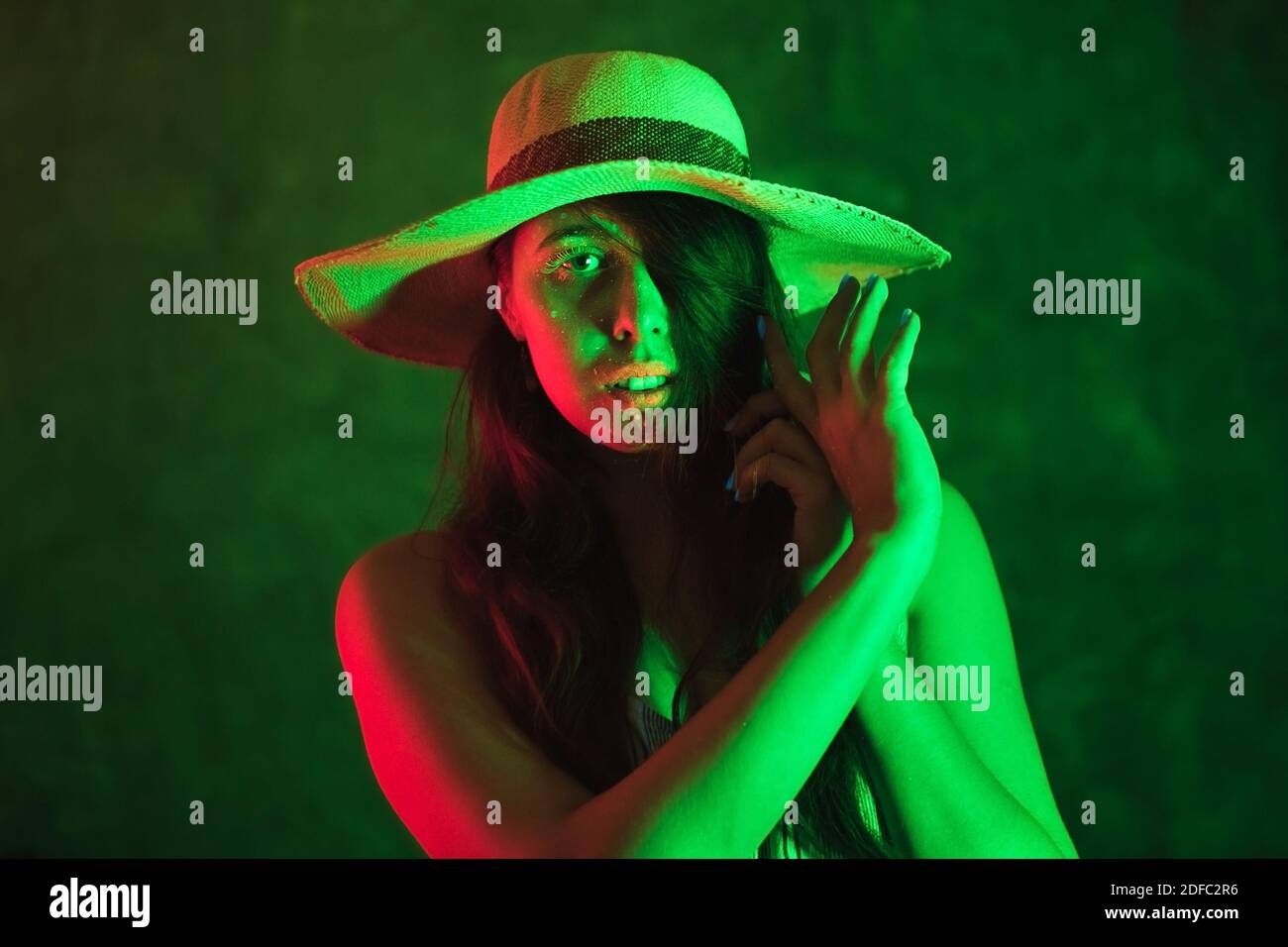 Fluorescent paint on young woman face in green colors. Ethnic, esoteric and art concept. Stock Photo