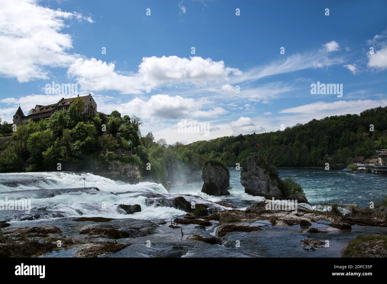 Das Schloss liegt am linken Ufer des Rheins auf einem steilen Felsen über dem Rheinfall und bietet einen Ausblick über den Rhein und den Wasserfall. Stock Photo
