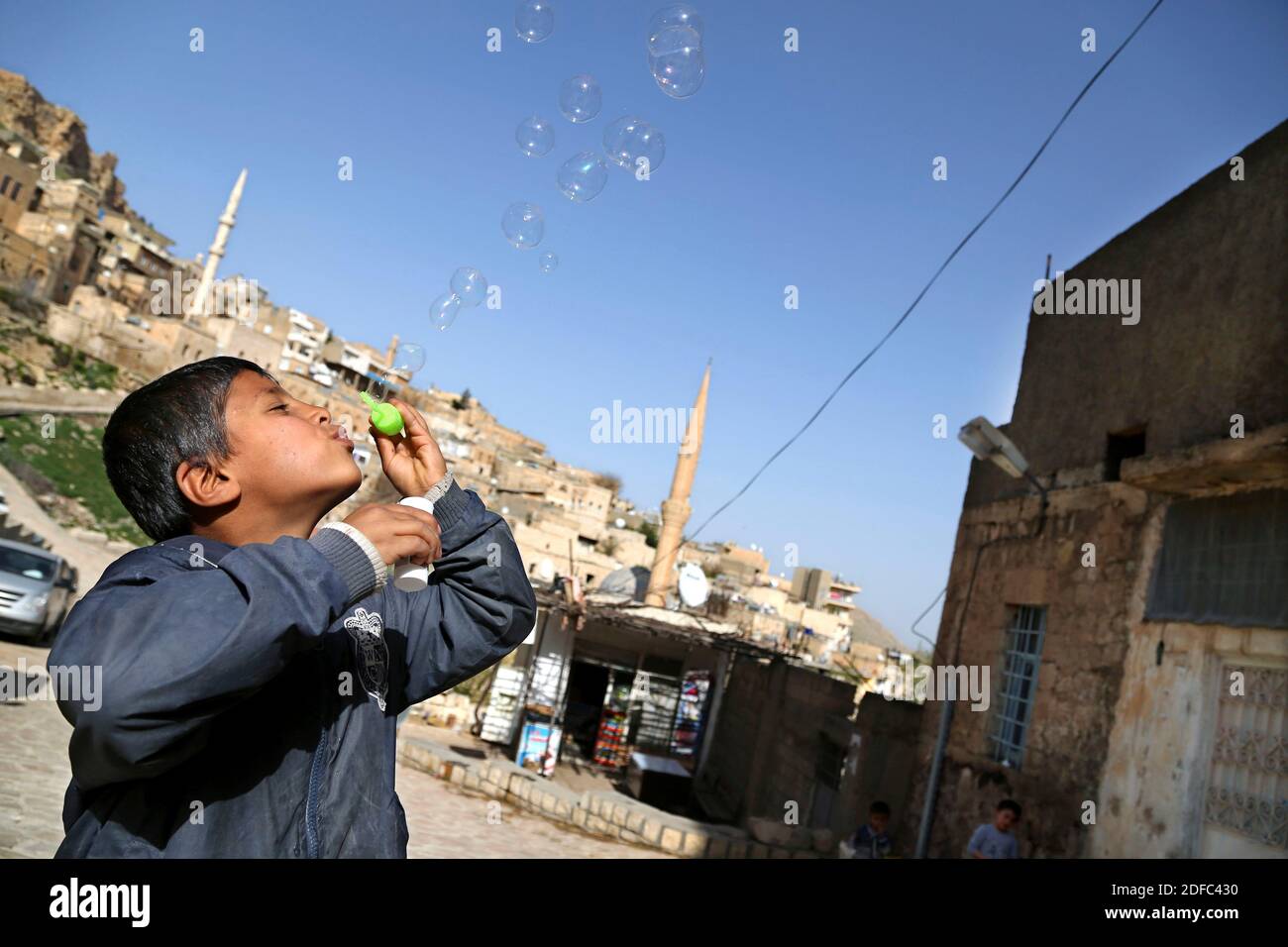 Turkey, a child plays with bubbles in the old town of Mardin Stock Photo