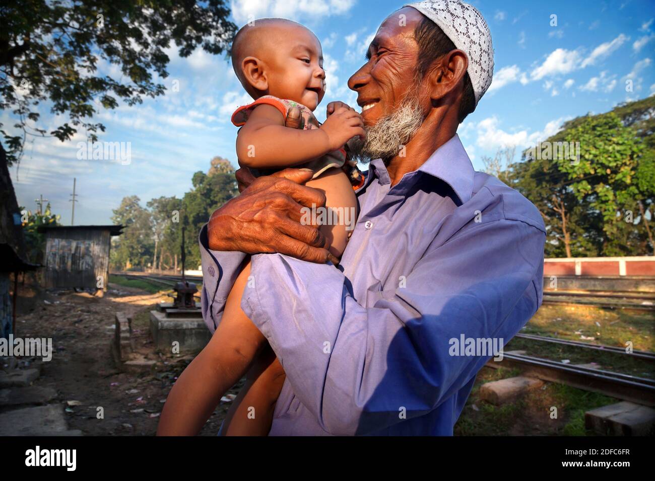 Bangladesh, happy smiling muslim grandfather with child in Sreemangal Stock Photo