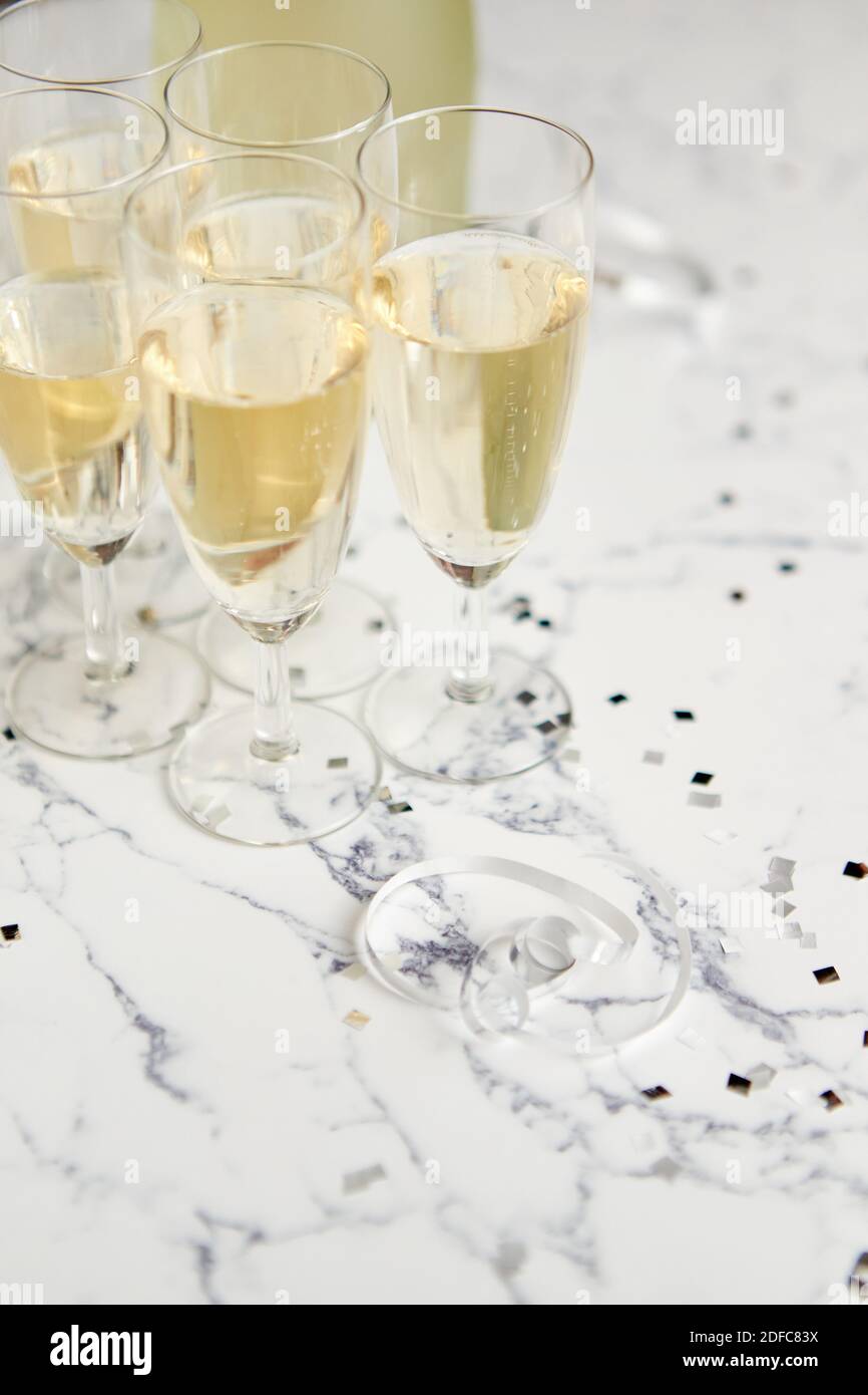 Champagne glasses and bottle placed on white marble background Stock Photo
