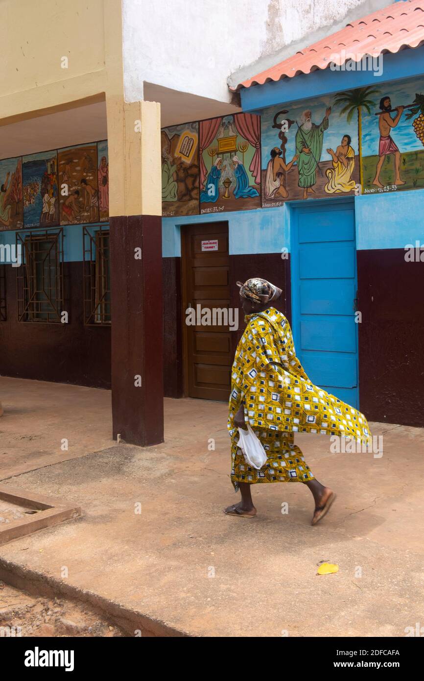 Togo, Togoville, woman walking in front of the frescoes of Notre dame du lac cathedral Stock Photo