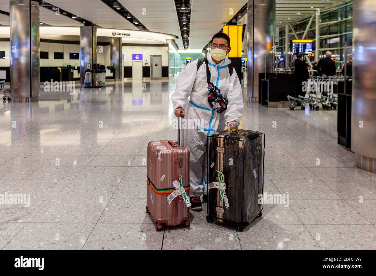 A Tourist Arrives From Asia In A Disposable Hazmat Protective Suit At Heathrow Airport During The Covid 19 Pandemic, London, UK. Stock Photo