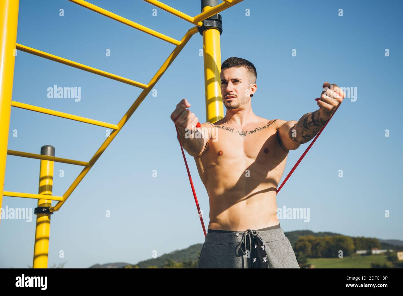 Athletic young man warm up by stretching a resistance band before