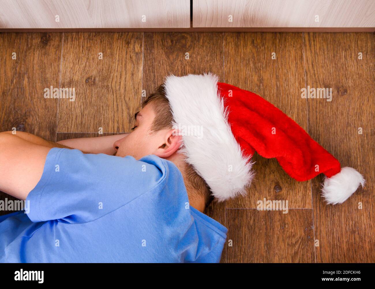 A Man in Santa Hat sleeping on the Floor Stock Photo