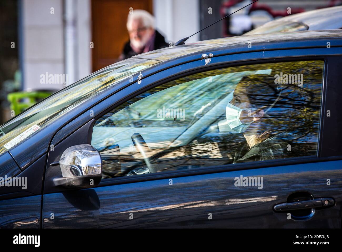 WOMAN, NURSE AT THE WHEEL OF HER CAR WEARING A MASK, COVID-19 PANDEMIC, PARIS, FRANCE, EUROPE Stock Photo