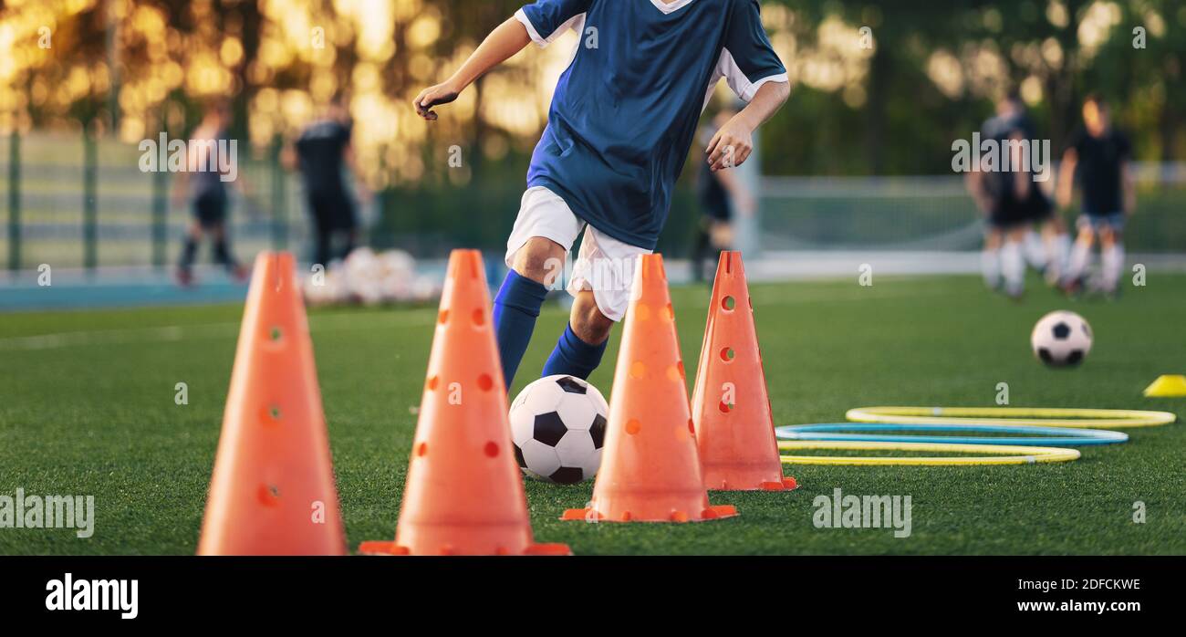 Football Player On Training Slalom Drill With Ball Soccer Boy Running Between Red Training Cones On Grass Practice Field Stock Photo Alamy