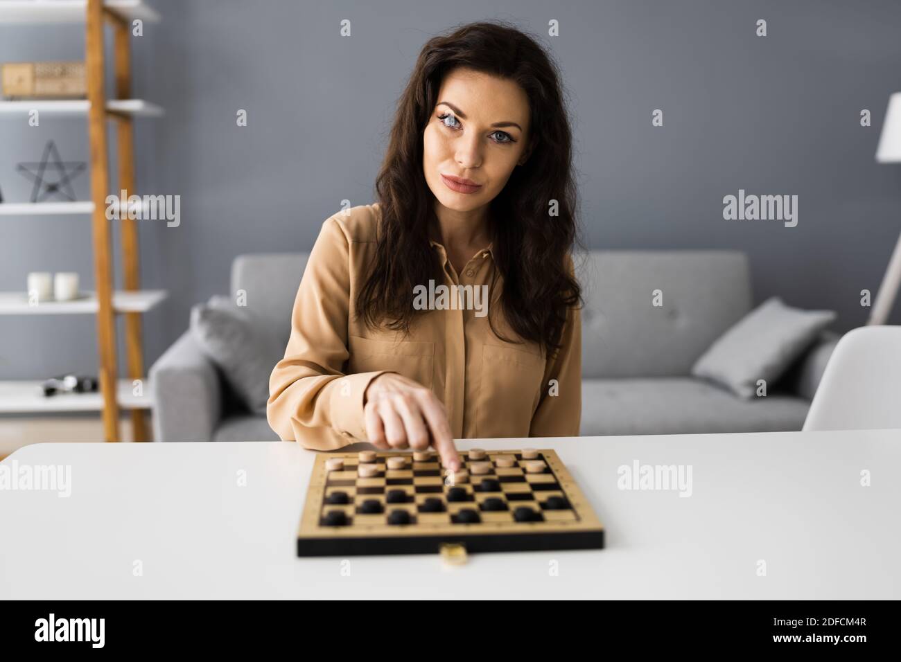 Woman Playing Checkers Online Using Video Conference Call Stock Photo