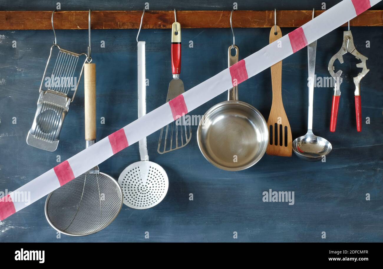 gastronomy corona lockdown, restaurant kitchen utensils with warning tape,symbolic picture Stock Photo