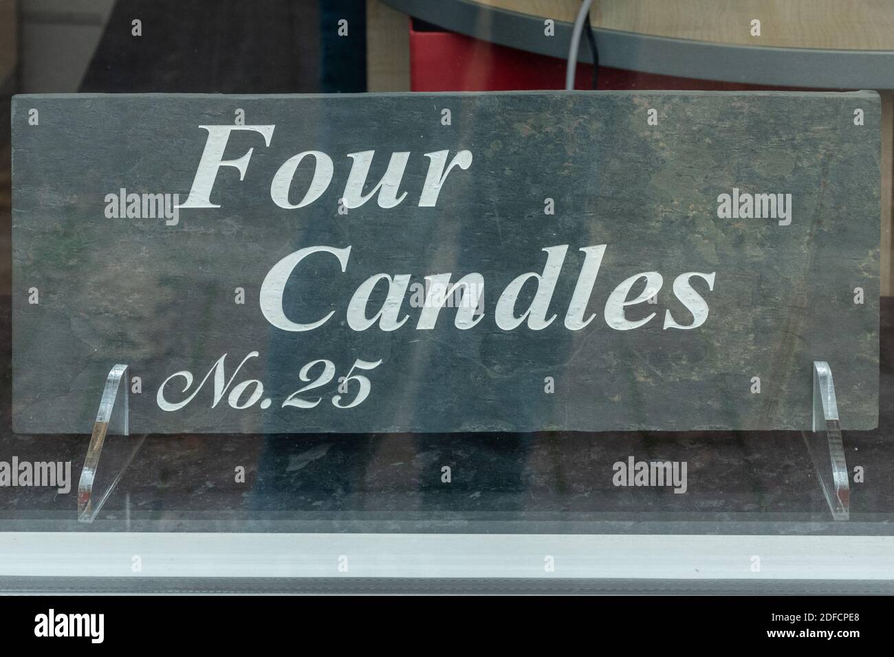 Slate house name plate Four candles in a shop window Stock Photo
