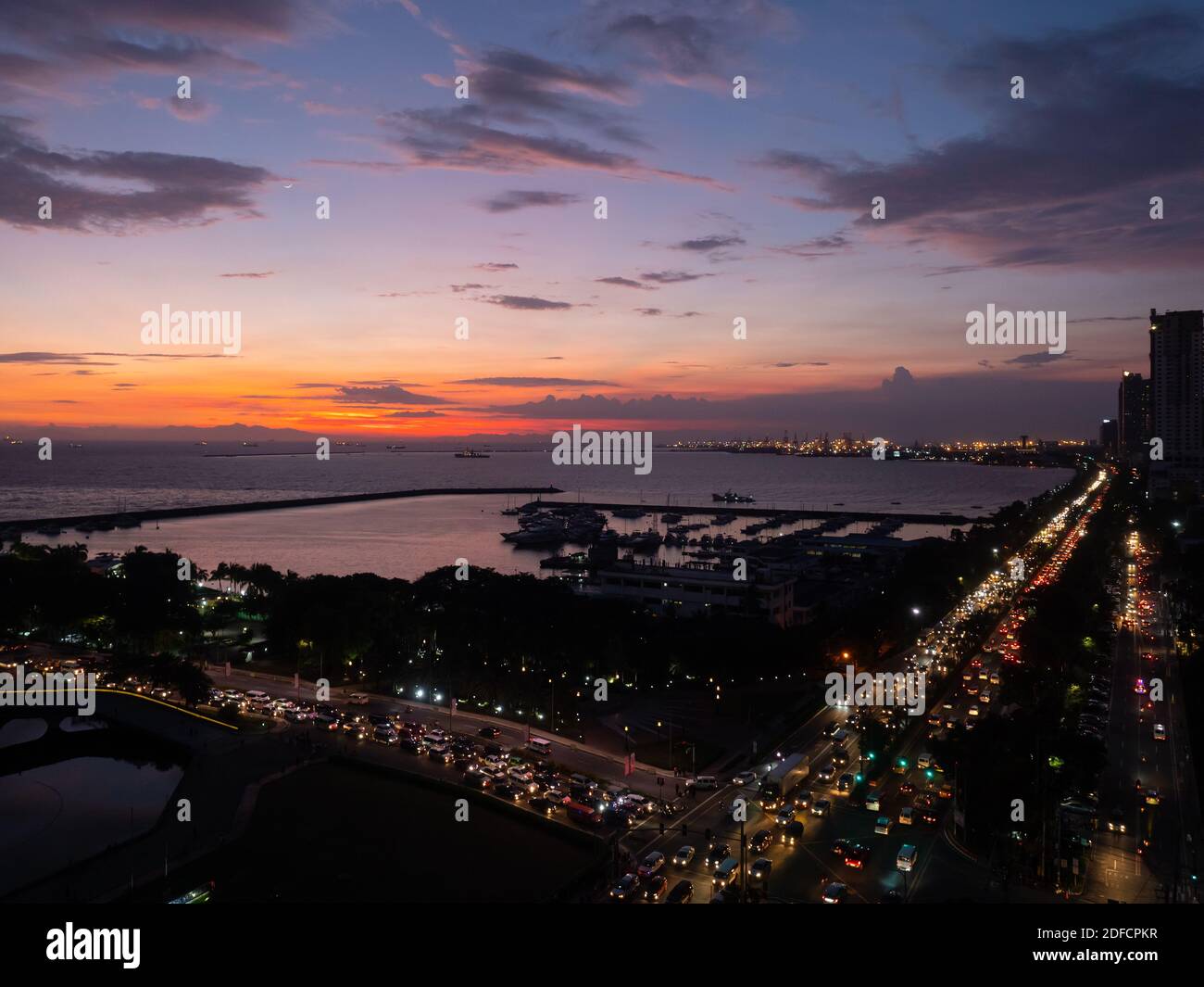 Evening at Manila Bay with Roxas Boulevard and Manila Yacht Club in the foreground. Stock Photo