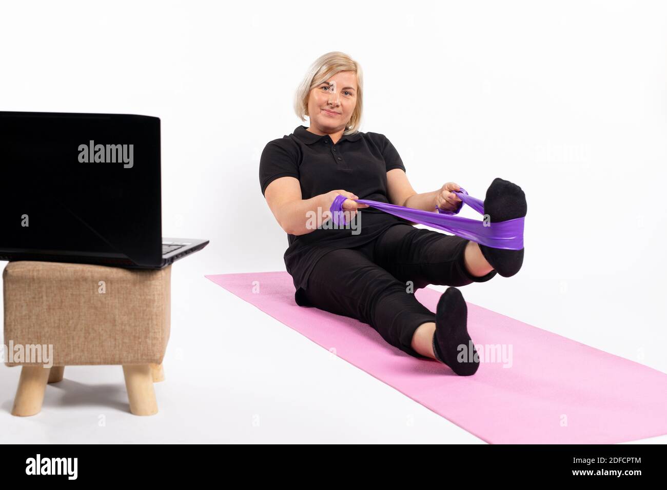 Senior woman doing exercise with an elastic band. Online training in quarantine Stock Photo Alamy