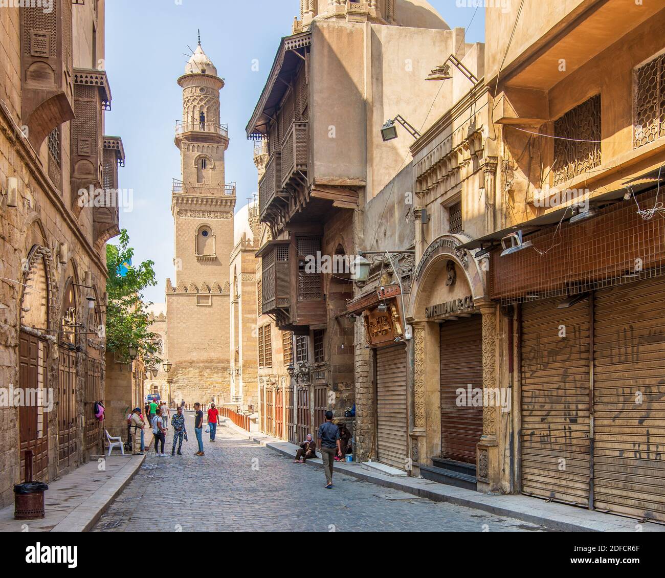 Cairo, Egypt- June 26 2020: Moez Street with workers, few local visitors and minaret of Qalawun Complex historic building, during Covid-19 lockdown period, Gamalia district, Old Cairo Stock Photo