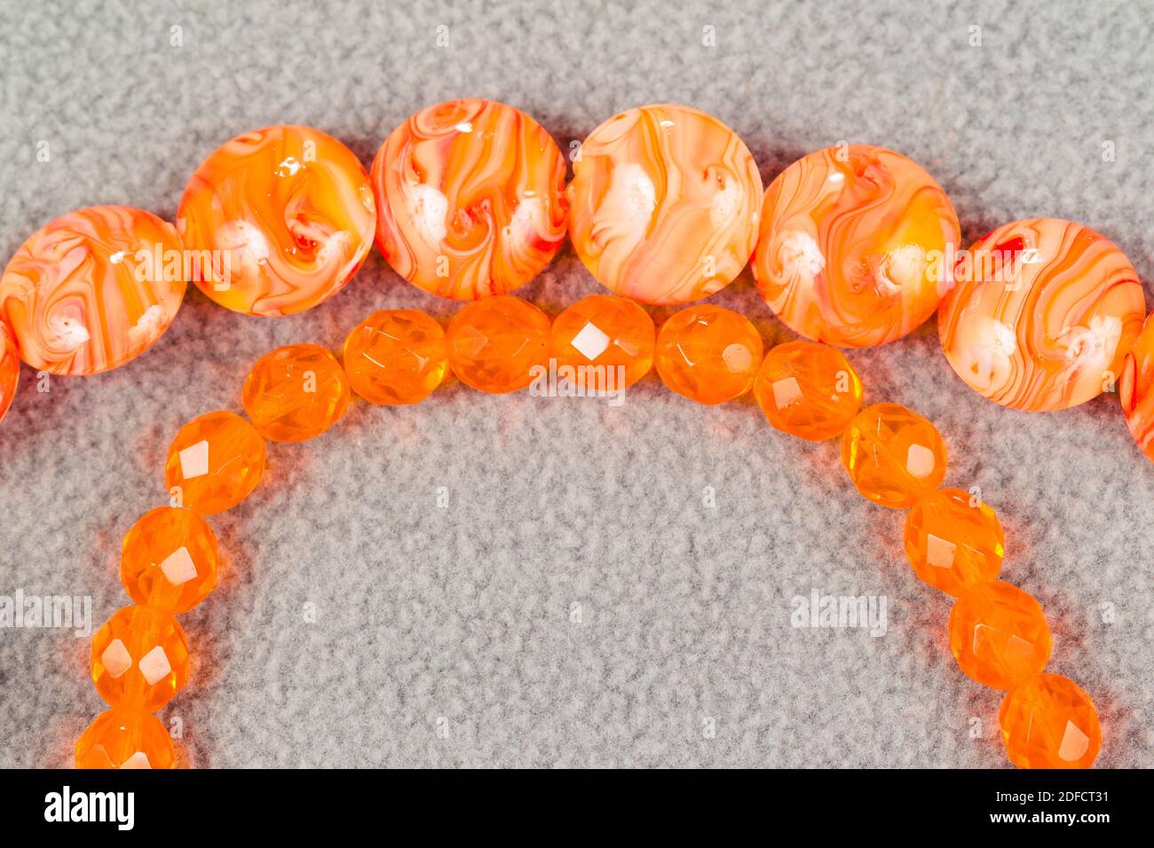 stands of round orange beads for the creation of jewelry Stock Photo