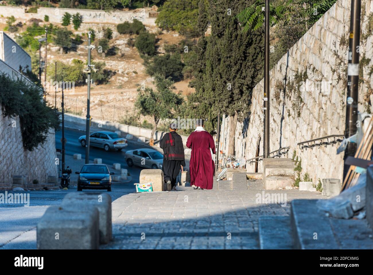 Two Christian pilgrims walking out from the Lions' Gate,  located in the Eastern Wall of Jerusalam old city, Islamic quarter, the entrance marks the b Stock Photo