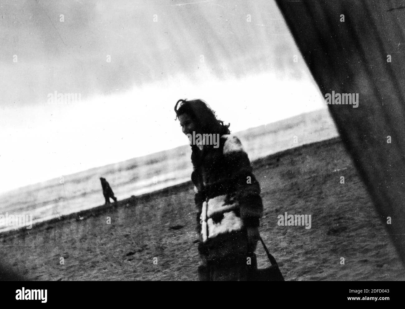 1960s 1970s Outdoor sea young woman  in black and white alone at the Tuscany beach of Castinglioncello. Italy. Scratches and blemishes scan Stock Photo