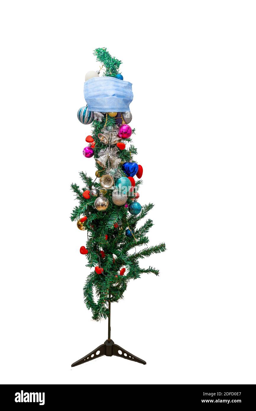 Merry Christmas in the new Covid-19. Front view of a Christmas tree with medical face mask. The concept of the new year during the pandemic Stock Photo