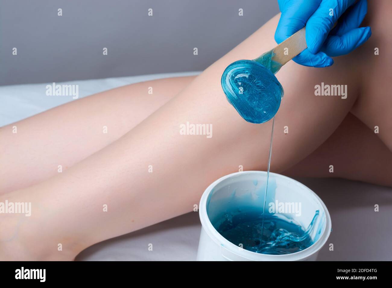 the procedure shugaring legs.the application of blue sugar paste.depilation in the salon Stock Photo