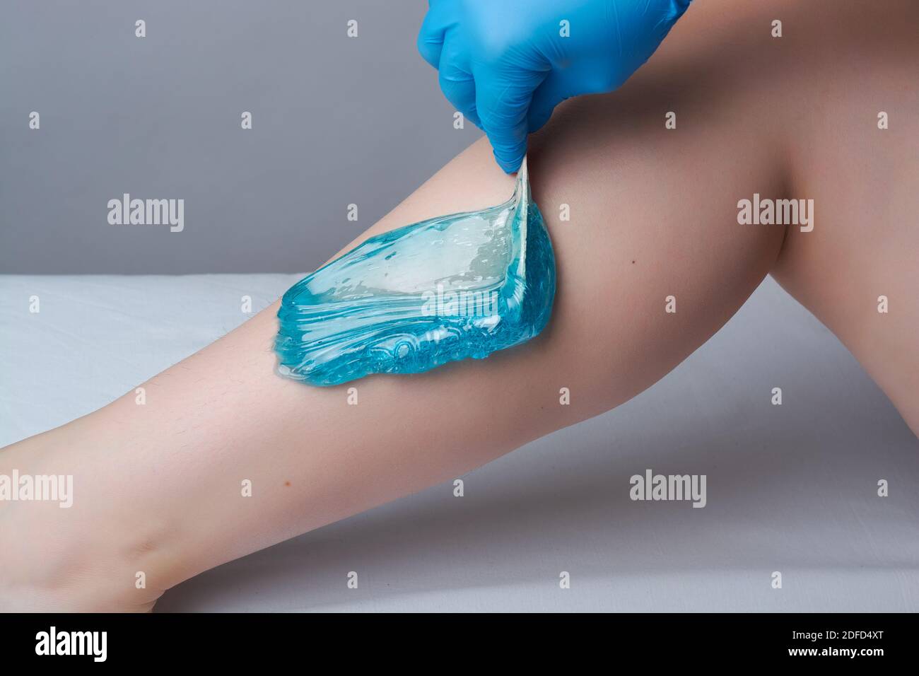 the procedure shugaring legs.the application of blue sugar paste.depilation in the salon Stock Photo