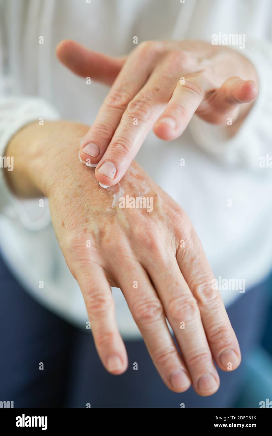 Woman applying cream on her hands. Stock Photo